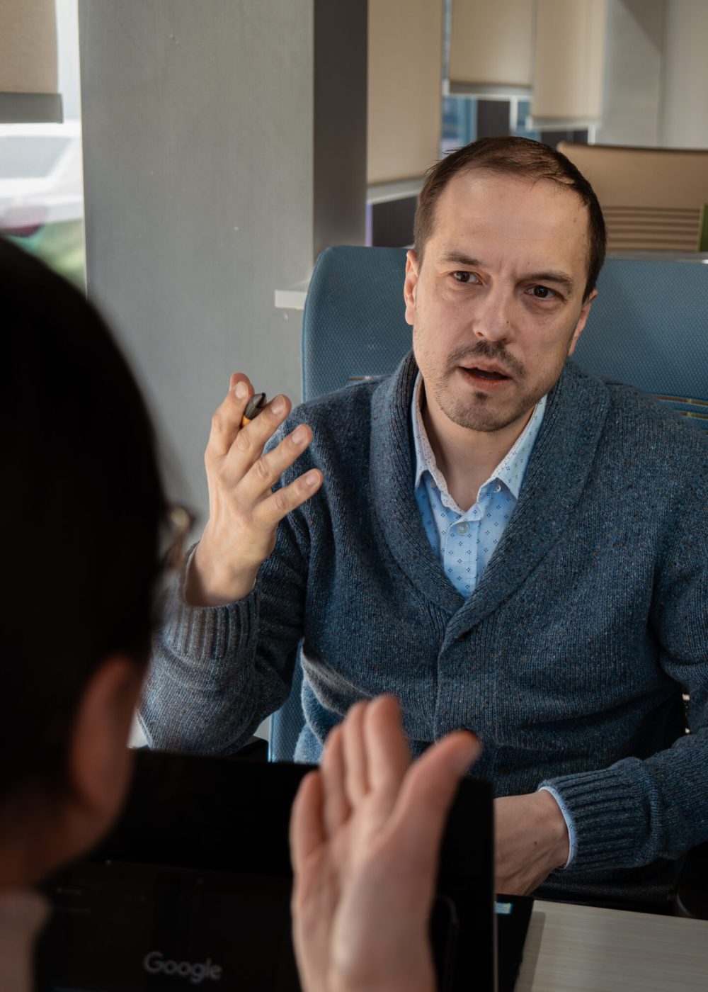 alex in an office in discussion with someone